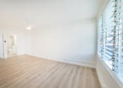 Thumbnail 13 of 23 - A room with wooden flooring and a window with blinds.