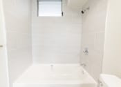 Thumbnail 24 of 33 - a white bathroom with a tub and a window