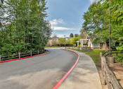 Thumbnail 6 of 46 - a curved road with a house and trees on the side of it
