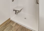 Thumbnail 33 of 46 - a white shower with grab bars and a stool in a bathroom