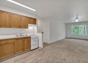 Thumbnail 28 of 46 - an empty kitchen with wood cabinets and white appliances and a window
