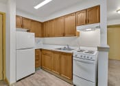 Thumbnail 27 of 46 - an empty kitchen with white appliances and wooden cabinets