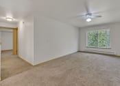 Thumbnail 34 of 46 - an empty living room with a ceiling fan and a window