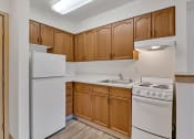 Thumbnail 36 of 46 - a kitchen with white appliances and wooden cabinets and a white refrigerator