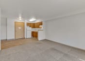 Thumbnail 37 of 46 - the living room and kitchen of an apartment with white walls and wood flooring