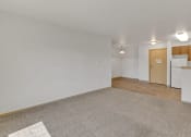 Thumbnail 40 of 46 - the living room and kitchen of an apartment with white walls and wood flooring