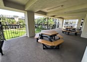 Thumbnail 7 of 20 - A patio with a black railing and a couple of benches.