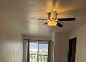 Thumbnail 12 of 24 - A room with a ceiling fan and sliding glass doors.