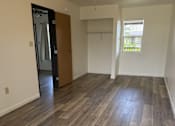 Thumbnail 13 of 24 - A room with a ceiling fan and wood flooring.