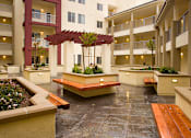 Thumbnail 1 of 5 - A courtyard with a bench and a tree in the middle.