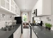 Thumbnail 3 of 25 - A modern kitchen with black countertops and white cabinets.