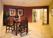 Thumbnail 2 of 5 - A dining room with a table and chairs.
