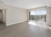 Thumbnail 3 of 17 - an empty living room with a large window and wood flooring