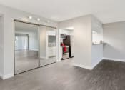 Thumbnail 9 of 17 - an empty living room with a large mirror and a kitchen