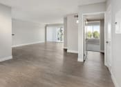 Thumbnail 13 of 17 - an empty living room with white walls and wood floors