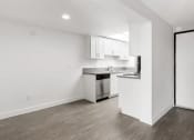 Thumbnail 16 of 17 - an empty living room and kitchen with white walls and wood floors