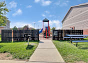 Thumbnail 5 of 21 - A playground with a slide and a playhouse.