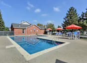 Thumbnail 1 of 21 - A red building with a pool in front of it.