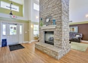 Thumbnail 9 of 21 - A stone fireplace in a room with a black rug in front of it.