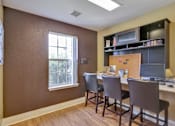 Thumbnail 10 of 21 - A brown room with a desk and chairs.