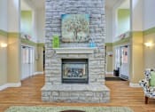 Thumbnail 4 of 21 - A stone fireplace with a painting above it in a room.