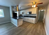 Thumbnail 3 of 18 - A kitchen with a black countertop and white cabinets.
