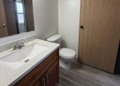 Thumbnail 16 of 24 - A bathroom with a sink, toilet, and mirror.