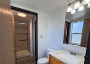 Thumbnail 17 of 24 - A bathroom with a toilet, sink, and mirror.