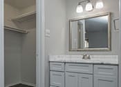 Thumbnail 18 of 20 - a bathroom with white cabinets and a sink and a mirror