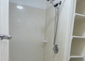 Thumbnail 8 of 13 - A white bathroom with a toilet and a walk in shower.