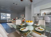 Thumbnail 12 of 20 - A dining room with a glass table and chairs.