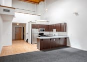 Thumbnail 13 of 25 - A kitchen with a refrigerator, sink, and cabinets.