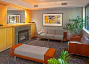 Thumbnail 10 of 25 - A living room with a grey sofa and a fireplace.
