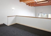 Thumbnail 16 of 25 - A room with a carpeted floor and a window with blinds.