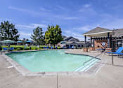 Thumbnail 11 of 20 - A large outdoor swimming pool with a pavilion and lounge chairs.