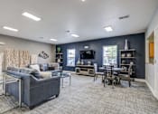 Thumbnail 4 of 20 - A living room with a grey couch and a glass coffee table.
