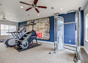 Thumbnail 16 of 20 - A home gym with a treadmill, elliptical trainer, and a wall with motivational words.