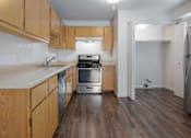 Thumbnail 9 of 15 - A kitchen with wooden cabinets and a stainless steel refrigerator.