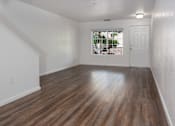 Thumbnail 8 of 15 - A room with wooden flooring and white walls.