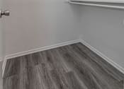 Thumbnail 15 of 20 - the closet in a small room with white walls and wood flooring