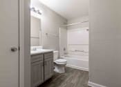 Thumbnail 18 of 22 - A small bathroom with a toilet, sink, and bathtub.