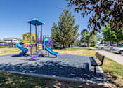 Thumbnail 5 of 22 - A playground with a purple slide and a yellow slide.