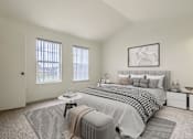 Thumbnail 13 of 22 - A bedroom with a large bed and a window with blinds.