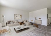 Thumbnail 12 of 22 - A modern living room with a white sofa, a coffee table, and a painting on the wall.