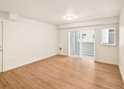 Thumbnail 6 of 8 - A room with wooden flooring and a window with bars.