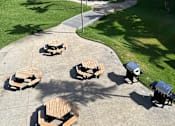 Thumbnail 5 of 20 - A park with benches and trees.