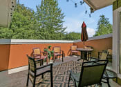 Thumbnail 9 of 46 - a patio with chairs and tables and an umbrella
