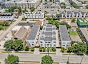 Thumbnail 29 of 32 - A bird's eye view of a residential area with apartment buildings and trees.