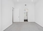 Thumbnail 20 of 32 - A white room with a door and a window.