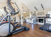 Thumbnail 10 of 20 - a gym with cardio equipment and a fireplace